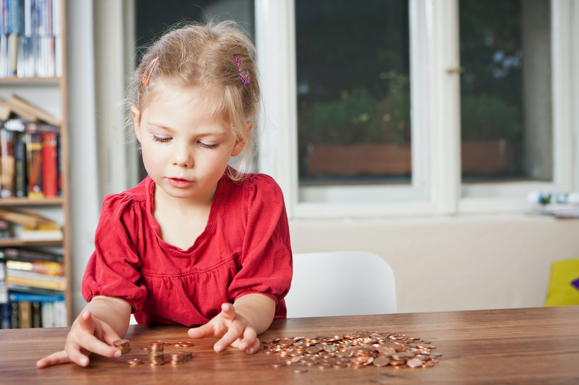 Girl playing with pennies at table